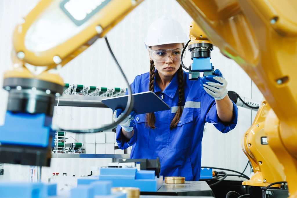 female automation machine engineer student study and inspection control robot arm machine in university or factory workshop. AI robot technology are new innovation trean for manufacturing in industry 5.0