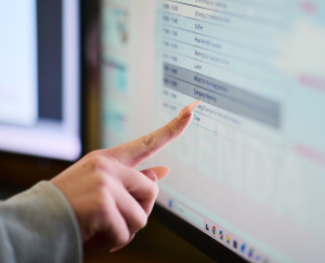 computer technology photo showing a hand pointing to software